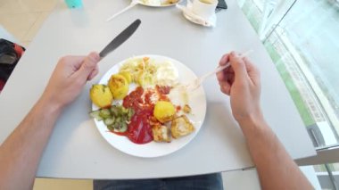 bir adam içinde baharatlar ile kızarmış patates kızarmış et yer. 4 k. ilk kişi üstten görünüm silah,.