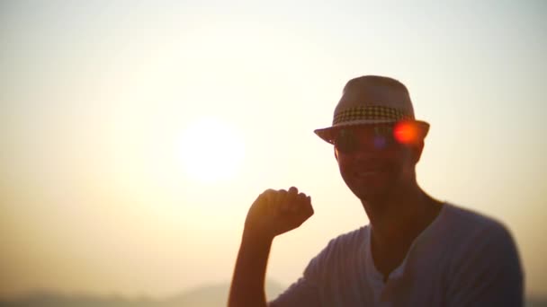 Joven con sombrero y gafas de sol viajando en barco al atardecer. 4k — Vídeos de Stock