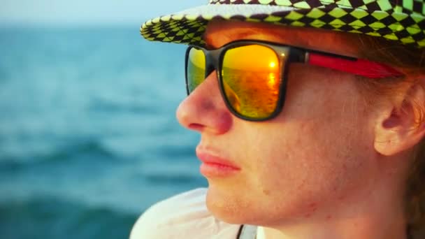 Young woman in hat and sunglasses traveling by boat at sunset. 4k — Stock Video