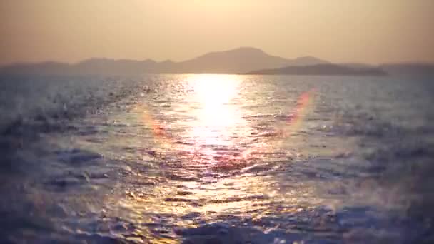 Vista do mar a partir do navio. O navio parte da ilha ao pôr-do-sol. 4k, borrão — Vídeo de Stock