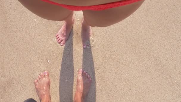 一对恋人, 在晴朗的晴天站在沙滩上。男人和女人的腿, 在沙滩上。4k. 慢动作 — 图库视频影像