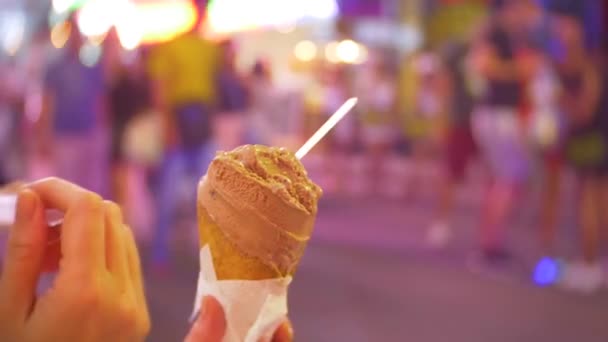 Jeune et belle femelle mange du dessert assis à l'extérieur dans un café ou une terrasse. Femelle est ravie de la crème glacée. 4k . — Video