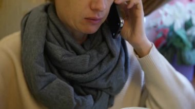 bir kadın bir smartphone kullanarak bir kafede yemek yiyorlar. 4k