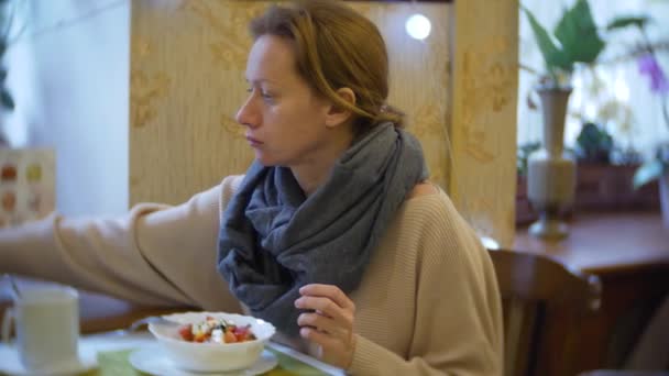 Mujer come ensalada de verduras en la cafetería, 4k — Vídeo de stock
