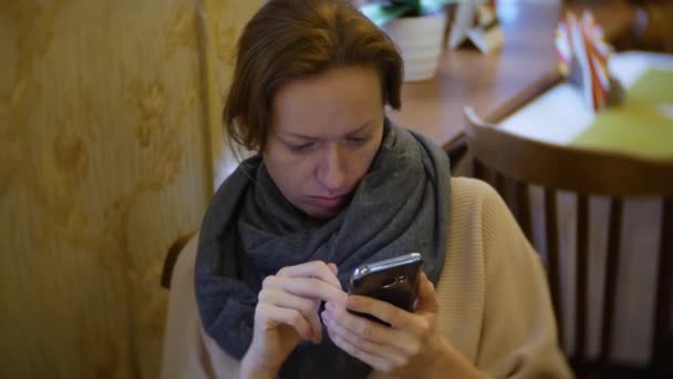 Kobieta jest obiad w kawiarni przy użyciu smartfonu. 4k — Wideo stockowe