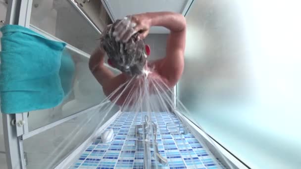 Junger schöner Mann nimmt eine Dusche. Blick von oben, Action-Kamera. 4k — Stockvideo