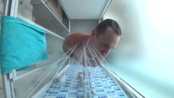 Junger schöner Mann nimmt eine Dusche. Blick von oben, Action-Kamera. 4k — Stockvideo