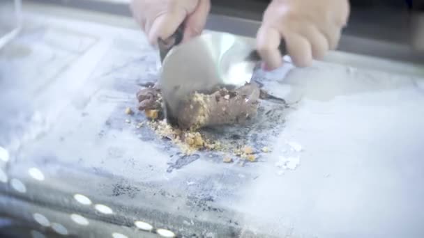 Кухар готує шоколадне морозиво з горіхами та печивом. 4 Кбайт, великим планом. Приготування морозива тайському стилі в Таїланді — стокове відео