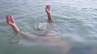 4k, ağır çekim silah, genç bir adam güneş gözlüğü denizde içine dalış. ortaya çıkıyor