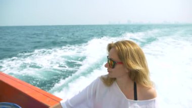 Güzel bir kadın geminin kıç üzerinde duruyor. Dalgalar içinde geçmiş, ağır çekim, 4k