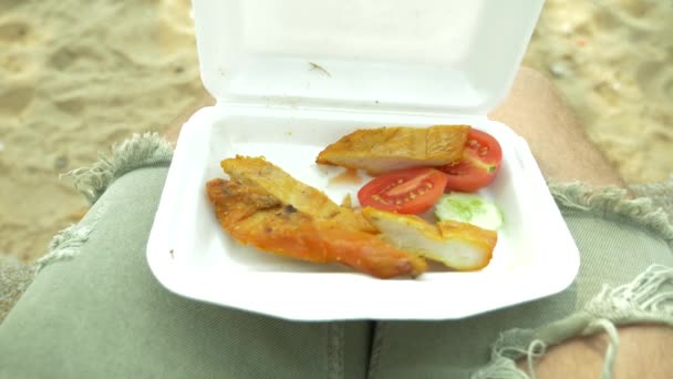 美味的炸鸡烧烤, 泰国菜的风格在一个集装箱, 泰国街头食品, 有人在海滩上吃鸡。4k. 慢动作 — 图库视频影像