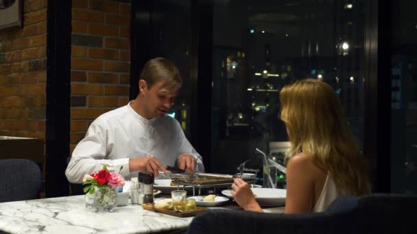 행복 한 커플 이야기 하 고 바에서 저녁 식사는 저녁에서 마천루를 내려다, 4 k, 배경 흐림 — 비디오