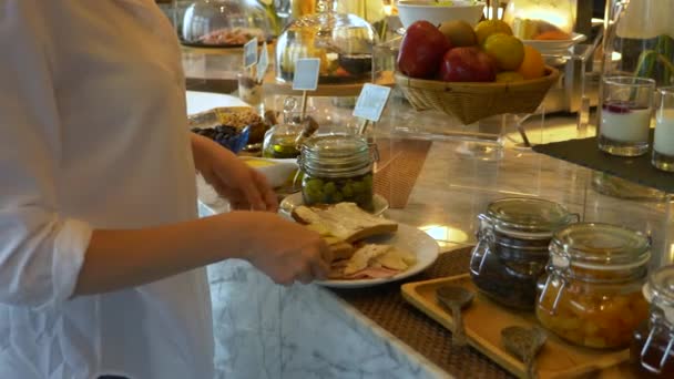 Self service ha preso il cibo dalla linea buffet. La donna sta preparando un panino per colazione. 4k . — Video Stock