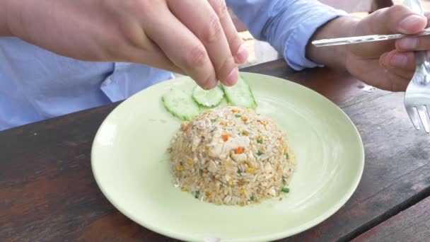 Nahaufnahme. 4k. Mann presst Limettensaft auf ein Gericht mit gebratenem Jasminreis mit Ei und Garnelen, garniert mit Gurken. — Stockvideo