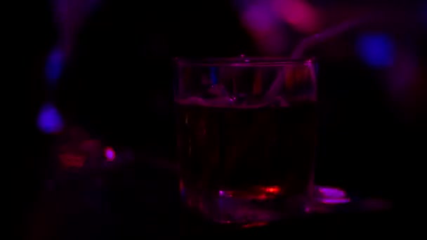 Nahaufnahme von Alkohol-Cocktail im Glas auf der Theke, in einem Nachtclub. Hintergrund verschwommen, 4k — Stockvideo