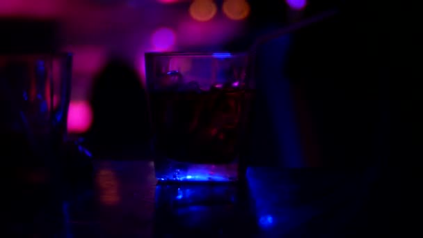 Nahaufnahme von Alkohol-Cocktail im Glas auf der Theke, in einem Nachtclub. Hintergrund verschwommen, 4k — Stockvideo