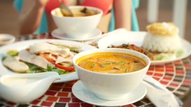 Krewetki pikantne zupy jest tajskie danie z kwaśny i ostry smak. Busty dziewczyna w bikini zjada Tom Yam przy stole przy basenie. 4 k, zwolnionym tempie, szczelnie-do góry. pojęcie turystyki podróży — Wideo stockowe
