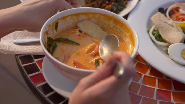 Prawn spicy soup is a Thai dish with sour and spicy taste. some are scooping prawn spicy soup. 4k, slow-motion, close-up — Stock Video