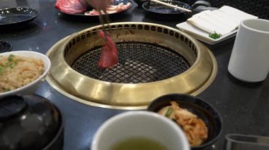 Korece barbekü ızgara. aşçı insanlar ve bir restoranda Kore bir ızgarada pişmiş yemekler yiyin. 4k, yakın çekim.