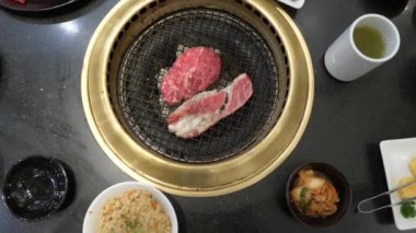 Korece barbekü ızgara. aşçı insanlar ve bir restoranda Kore bir ızgarada pişmiş yemekler yiyin. 4k, yakın çekim.
