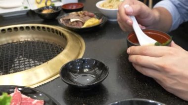 Korece barbekü ızgara. aşçı insanlar ve bir restoranda Kore bir ızgarada pişmiş yemekler yiyin. 4k, yakın çekim.