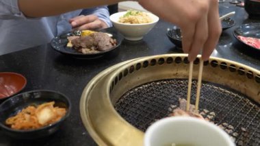 Korece barbekü ızgara. aşçı insanlar ve bir restoranda Kore bir ızgarada pişmiş yemekler yiyin. 4k, yakın çekim.