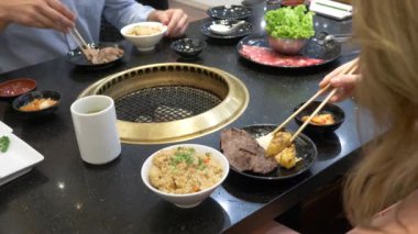 Korece barbekü ızgara. aşçı insanlar ve bir restoranda Kore bir ızgarada pişmiş yemekler yiyin. 4k, yakın çekim.
