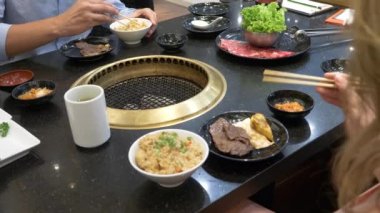 Korece barbekü ızgara. aşçı insanlar ve bir restoranda Kore bir ızgarada pişmiş yemekler yiyin. 4k, yakın çekim.