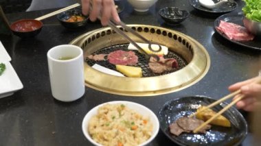 Korece barbekü ızgara. aşçı insanlar ve bir restoranda Kore bir ızgarada pişmiş yemekler yiyin. 4k, yakın çekim.