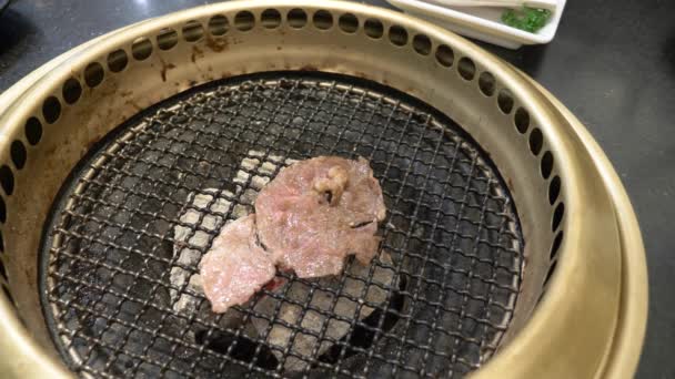 Barbecue coréen. les gens cuisinent et mangent des plats cuisinés sur un gril coréen dans un restaurant. 4k, gros plan . — Video