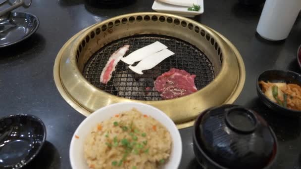 Churrasqueira coreana. as pessoas cozinham e comem pratos cozidos em um churrasco coreano em um restaurante. 4k, close-up . — Vídeo de Stock