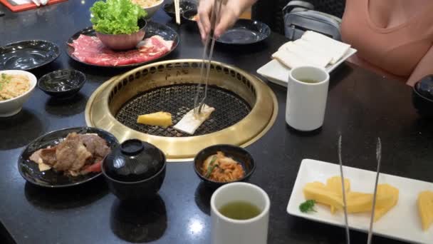 Koreansk grill grill. människor cook och äta rätter som tillagas på en koreansk grill i en restaurang. 4k, närbild. — Stockvideo