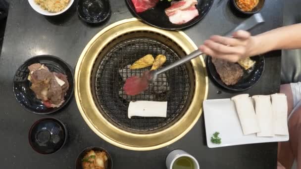 Korean barbecue-grill. ludzie gotować i jeść potrawy przyrządzone na Koreański grill w restauracji. 4k, zbliżenie. — Wideo stockowe