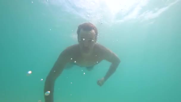 Un homme plonge dans une mer cristalline dans un masque une personne immergée dans une mer cristalline et fait du selfie sous l'eau. 4ksnorkel. 4k — Video