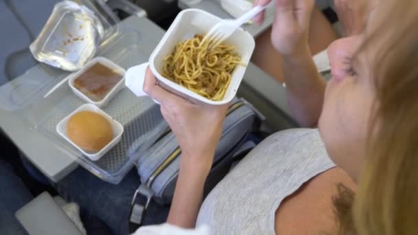 4k, szczegół. kobieta jest obiad w samolocie. Podczas lotu — Wideo stockowe