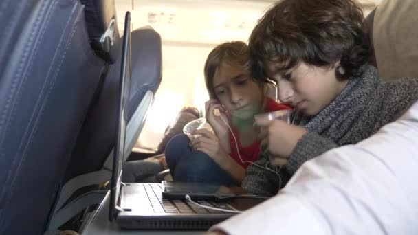 4 k, close-up, kinderen, passagiers water drinken uit wegwerp bekers in het vliegtuig tijdens de vlucht tegen de patrijspoort. — Stockvideo