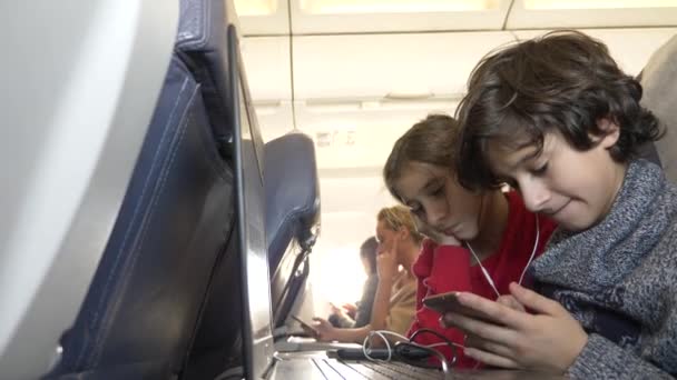 4k, primo piano, bambini, passeggeri usano il telefono in aereo contro l'oblò . — Video Stock