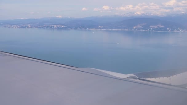 Крыло крыла самолета. Вид на море и горы с самолета во время взлета или посадки. 4k — стоковое видео