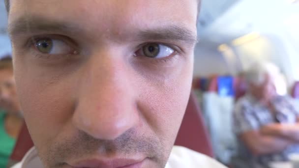 4k, närbild. A mans ansikte under ett flygplan flygning upplever Aeropfobi. — Stockvideo