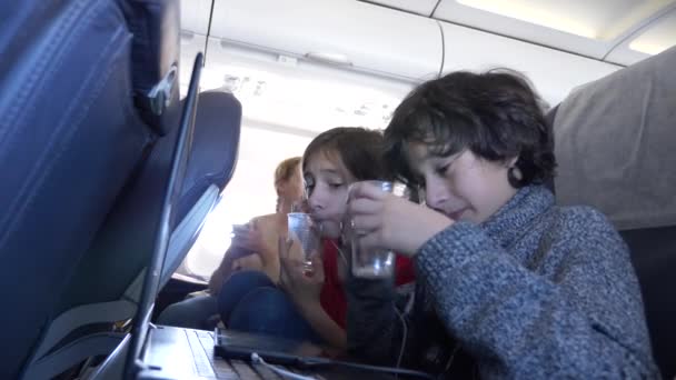 4 k, γκρο πλαν, παιδιά, οι επιβάτες που χρησιμοποιούν το τηλέφωνο σε ένα αεροπλάνο κατά το φινιστρίνι. — Αρχείο Βίντεο