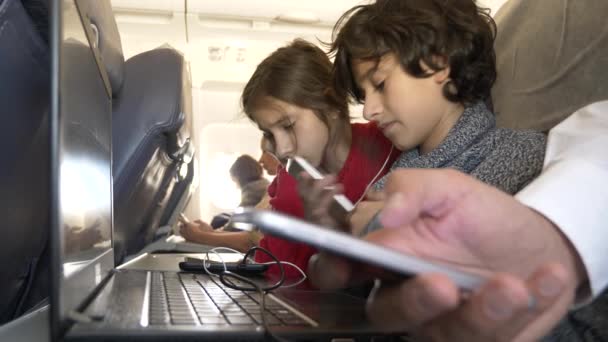 4 k, γκρο πλαν, παιδιά, οι επιβάτες που χρησιμοποιούν το τηλέφωνο σε ένα αεροπλάνο κατά το φινιστρίνι. — Αρχείο Βίντεο