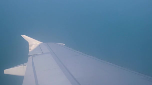 Ala di ala di aereo. Vista del mare e delle montagne dall'aereo durante il decollo o l'atterraggio. 4k — Video Stock