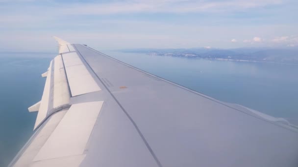 Ala del ala del avión. Una vista del mar y las montañas desde el avión durante el despegue o aterrizaje. 4k — Vídeos de Stock