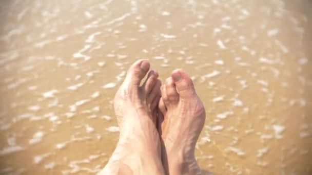 Mens piernas en la playa en el fondo de una ola de 4k, cámara lenta — Vídeos de Stock