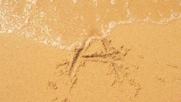 The sea wave erases the inscriptions written on the sand. 4k, slow-motion, top view, the letter a — Stock Video