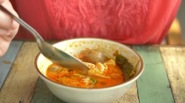 kadın Tom Yam sahilde, 4 k yavaş hareket oturan yeme Tay çorba