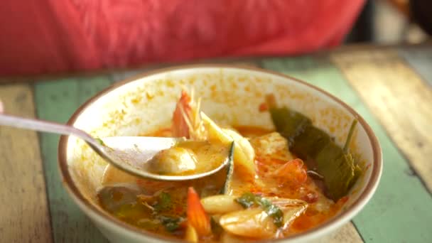 Woman eating Thai soup Tom Yam sitting on the beach, 4k slow-motion — Stock Video