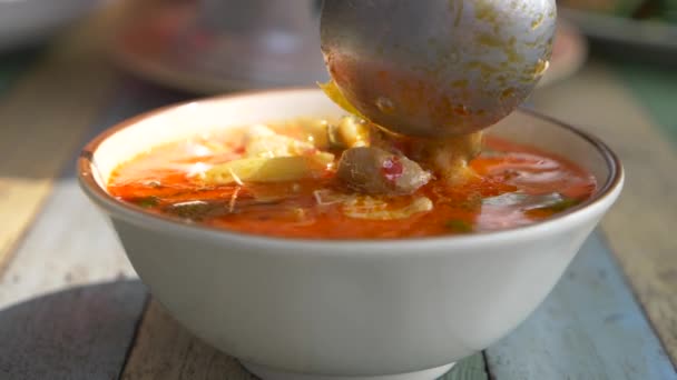 Mujer comiendo sopa tailandesa Tom Yam sentado en la playa, 4k cámara lenta — Vídeo de stock