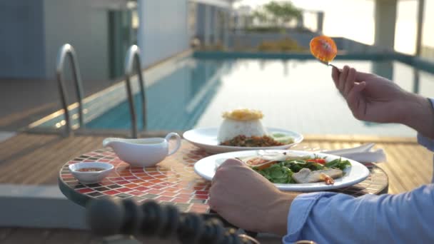 Sopa de camarão é um prato tailandês com um sabor azedo e picante. o homem está comendo Tom Yam em uma mesa à beira da piscina. 4K, câmara lenta, close-up. conceito de turismo turismo — Vídeo de Stock