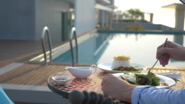 Shrimp soup is a Thai dish with a sour and spicy taste. the man is eating Tom Yam at a table by the pool. 4k, slow motion, close-up. concept of tourism tourism — Stock Footage Shrimp soup is a Thai dish with a sour and spicy taste. the man is eating Tom Yam at a table by the pool. 4k, slow motion, close-up. concept of tourism tourism Video Clip
